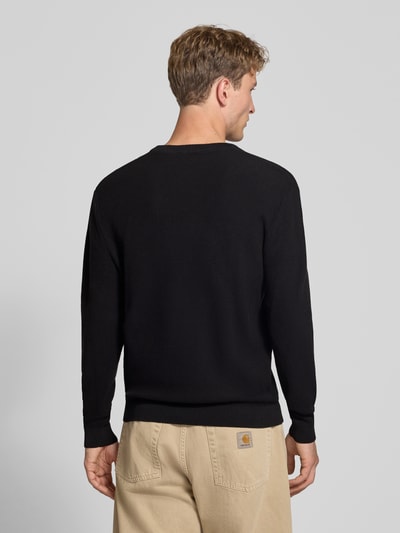 Männermodel trägt Regular Fit Pullover aus reiner Baumwolle Modell 'TONY' von ONLY & SONS in Schwarz, strukturierte Oberfläche, Ganzkörperansicht Rückansicht.