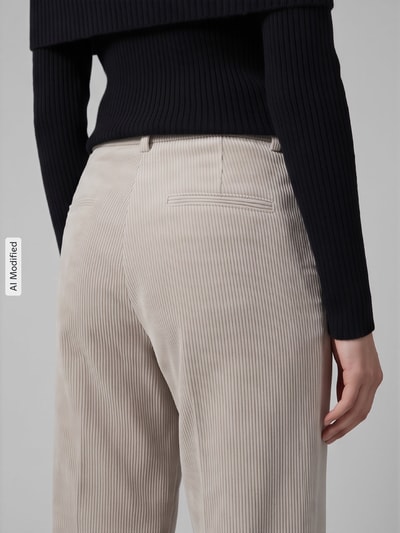 Frauenmodel trägt Regular Fit Cordhose mit angedeuteten Taschen Modell 'AMELIE' von CAMBIO, cremefarben, feine Cordstruktur, Nahaufnahme Rückansicht, KI-modifiziertes Bild.