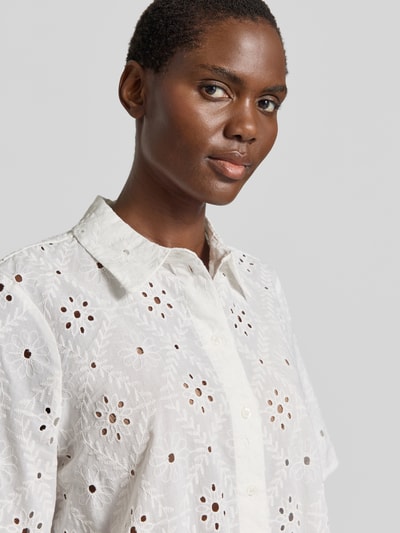 Kobiece model prezentuje bluzkę koszulową Relaxed Fit Hemdbluse aus reiner Baumwolle Modell 'ELIZA' od Vero Moda, efekt: jednolity kolor, haft angielski, kołnierzyk koszulowy, dekolt w serek, listwa guzikowa, rękaw o dł. 1/2, materiał: bawełna; zbliżenie na górę ciała.