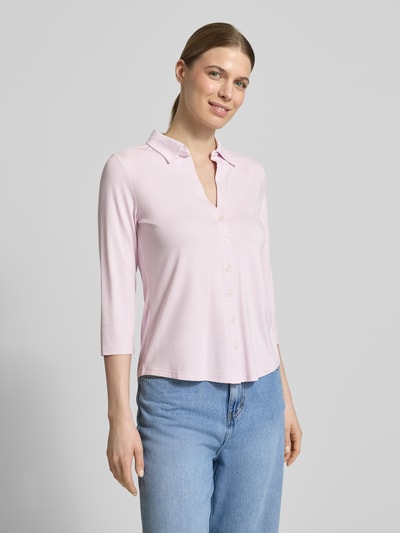 Kobiece model prezentuje Regular Fit Hemdbluse aus Viskose-Mix od Marc O'Polo, efekt: jednolity kolor, krój regular fit, kołnierzyk koszulowy, dekolt w serek, rękaw o dł. 3/4, wykończenie lekko zaokrąglone, mieszanka wiskozy, jasnoróżowy, gładka tekstura, widok całej sylwetki z przodu.