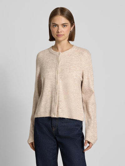 Frauenmodel trägt Loose Fit Strickjacke mit Rundhalsausschnitt Modell 'SIMONI' von ONLY in Beige, kombiniert mit Jeans, Ganzkörperansicht von vorne, Damen Strickjacke von ONLY.
