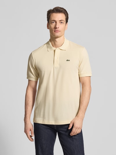 Männermodel trägt Regular Fit Poloshirt aus Baumwoll-Mix von Lacoste, Optik: Unifarben, Logo-Detail, Piqué, Ganzkörperansicht von vorne.