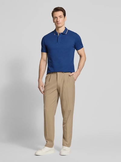 Männermodel trägt Slim Fit Poloshirt aus Baumwolle von Colmar Originals, dunkelblau, kurze Ärmel, Polokragen, Ganzkörperansicht von vorne.