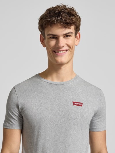 Männermodel trägt T-Shirt mit Label-Print im 2er-Pack von Levi's®, reine Baumwolle, Regular-Fit, graue Farbe, Nahaufnahme Oberkörper.