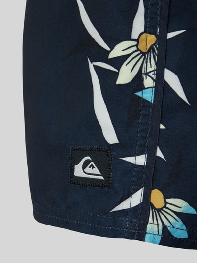 Productfoto, Badeshorts im allover-look van Quiksilver in donkerblauw met witte en gele bloemmotieven, regular fit, elastische band met tunnelkoord