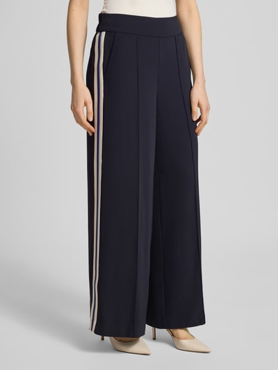 Frauenmodel trägt Stoffhose mit elastischem Bund von Comma, Material-Mix mit Stretch-Anteil, Ziernähte, ausgestellter Schnitt, Ganzkörperansicht von vorne.