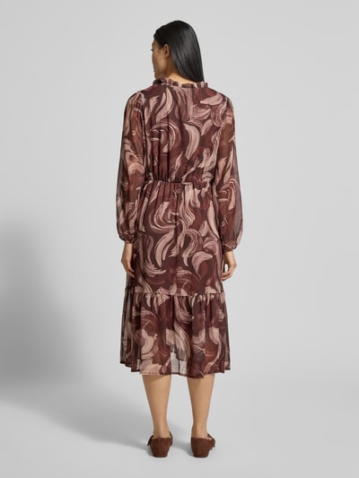 Frauenmodel trägt Midikleid mit V-Ausschnitt Modell 'Za44raa' von ZABAIONE in Braun mit Stufen-Look und A-Linie, Ganzkörperansicht Rückansicht