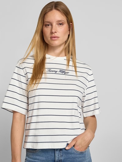 Frauenmodel trägt Regular Fit T-Shirt aus reiner Baumwolle von Tommy Hilfiger, weiß mit dunkelblauen Streifen, Nahaufnahme Oberkörper. Damen T-Shirt von Tommy Hilfiger.