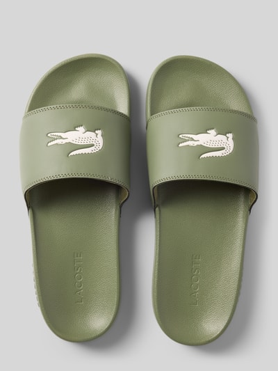 Produktfoto, Badeschuhe mit Logo-Print Modell 'SERVE SLIDE 0.0' von Lacoste in Optik: Unifarben mit runder Schuhspitze, flacher Absatzform, Applikation: Logo-Print, Verschluss: Schlupf/offen, strukturierte Sohle