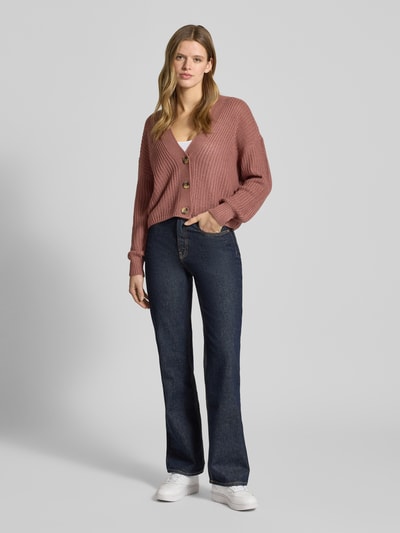 Frauenmodel trägt Regular Fit Strickjacke mit einreihiger Knopfleiste Modell 'CAROL NICE' von Only in Unifarben, Strickoptik, Ganzkörperansicht von vorne.