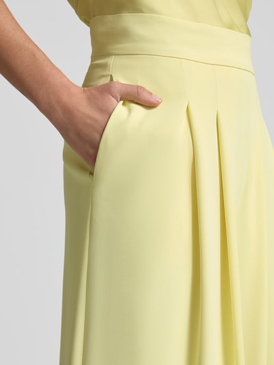 Frauenmodel trägt Stoffhose mit französischen Eingrifftaschen von Rinascimento, gelb, glatte Textur, Material-Mix, Nahaufnahme Oberkörper.
