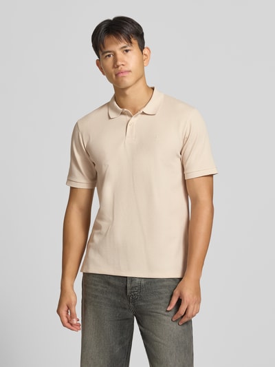 Męski model nosi Regular Fit Poloshirt mit Baumwoll-Anteil Modell 'Austin' von JACK & JONES w kolorze beżowym, strukturalny wzór, logo haftowane, krótkie rękawy, elastyczne wykończenia, boczne rozcięcia, kołnierzyk polo, materiał elastyczny z bawełną, długość tyłu w rozmiarze M 68 cm, widok całej sylwetki z przodu.