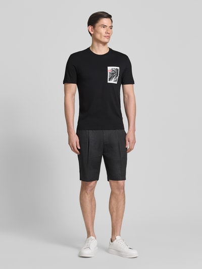 Männermodel trägt Regular Fit T-Shirt aus reiner Baumwolle Modell 'TE_BOARD' von BOSS Orange, unifarben, Foto-Print, Ganzkörperansicht von vorne.