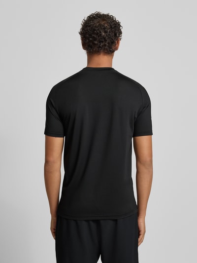 Männermodel trägt T-Shirt mit Label-Print von EA7 Emporio Armani aus Material-Mix mit Stretch-Anteil, Slim Fit, Rückenlänge 69 cm, Ganzkörperansicht Rückansicht.