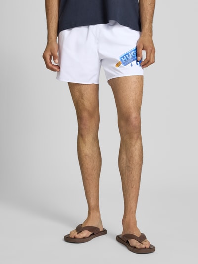 Männermodel trägt Badeshorts mit Motiv-Print von Hugo Blue, Optik: Unifarben, Gesäßtasche, seitliche Eingrifftaschen, Popeline, Nahaufnahme Unterkörper.