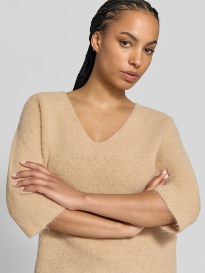 Vrouwenmodel draagt Wollpullover aus Alpaka-Woll-Mix van Juvia in beige met v-hals, tricotlook, 3/4-mouw, rolzoom, Nahaufnahme bovenlichaam