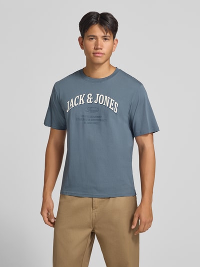 Männermodel trägt Regular Fit T-Shirt aus reiner Baumwolle Modell 'Denver' von JACK & JONES, Blau mit Logo-Print, Nahaufnahme Oberkörper. Herren T-Shirt, Rückenlänge bei Größe M 69 cm.