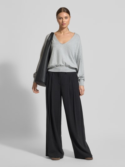 Frauenmodel trägt Strickpullover aus Baumwoll-Kaschmir-Mix Modell 'RISORY' von Drykorn in Grau, Relaxed-Fit, V-Ausschnitt, Ganzkörperansicht von vorne.