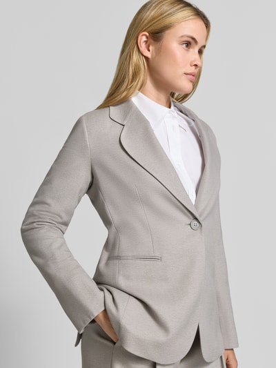 Frauenmodel trägt Blazer mit Reverskragen und Brustleistentasche von Emporio Armani in Hellgrau, Material-Mix, Nahaufnahme Oberkörper.