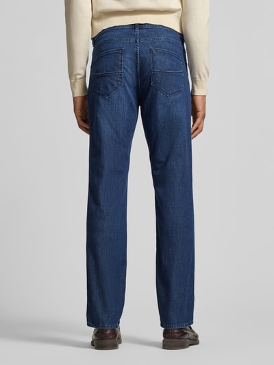 Männermodel trägt Jeans im Used-Look Modell 'Cadiz' von Brax, Regular Fit, Baumwoll-Mix, dunkelblau, Eingrifftaschen, Ganzkörperansicht Rückansicht.