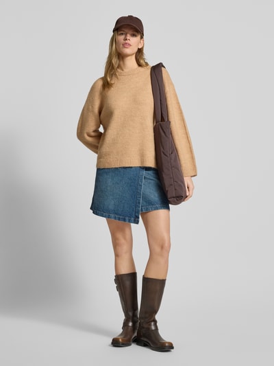 Frauenmodel trägt Sweter z dzianiny z dodatkiem wełny od Gina Tricot w kolorze beżowym, luźny krój, prążkowane wykończenia, okrągły dekolt, materiał-mix; długość tyłu 59 cm, długość rękawów 66 cm, Ganzkörperansicht von vorne.
