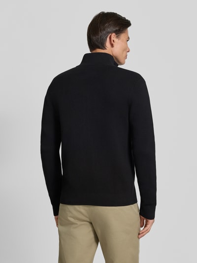 Männermodel trägt schwarze Regular Fit Jacke aus reiner Baumwolle Modell 'MILANO' von JACK & JONES, Strick-Optik, Ganzkörperansicht Rückansicht.