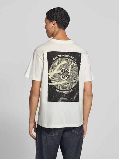 Männermodel trägt T-Shirt mit Label-Print von Replay in Weiß und Schwarz aus reiner Baumwolle, gerader Schnitt, Rückenansicht, Ganzkörperansicht. Rückenlänge bei Größe M: 68 cm, Kontext: Herren T-Shirt von Replay.