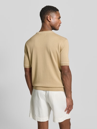 Männermodel trägt Strickshirt mit Rundhalsausschnitt von Gant in Beige, gerader Schnitt, Kurzarm, Baumwoll-Modal-Mix, Ganzkörperansicht Rückansicht.