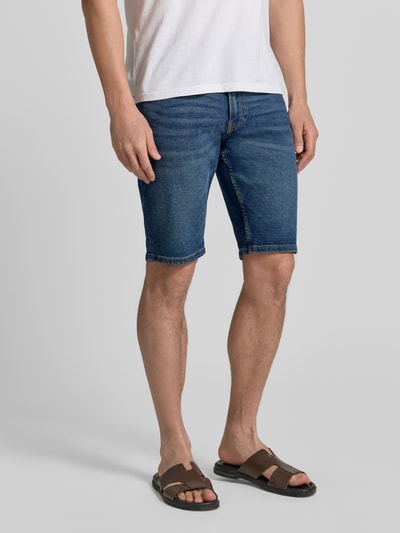 Männermodel trägt Regular Fit Jeans-Bermudas aus Baumwoll-Mix von s.Oliver RED LABEL in klassischem Denim-Blau, 5-Pocket-Design, Ganzkörperansicht von vorne.