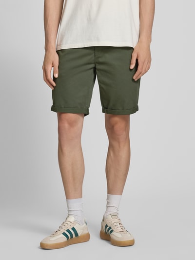 Männermodel trägt Shorts mit Gürtel Modell 'MIKE' von Redefined Rebel in Oliv, Regular-Fit, Eingrifftaschen, Ganzkörperansicht von vorne.