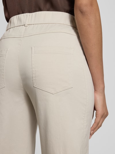 Frauenmodel trägt Straight Fit Stoffhose mit Eingrifftaschen Modell 'Ornela' von STEHMANN aus elastischem Baumwoll-Mix in Beige, Detailaufnahme Rückansicht.