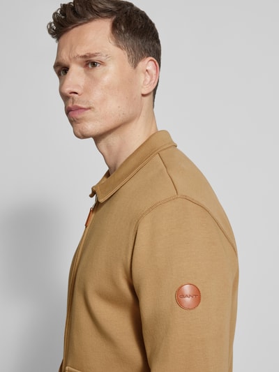 Männermodel trägt Sweatjacke mit Pattentaschen Modell 'PONTE DI ROMA' von Gant in Beige, reine Baumwolle, Nahaufnahme Oberkörper.