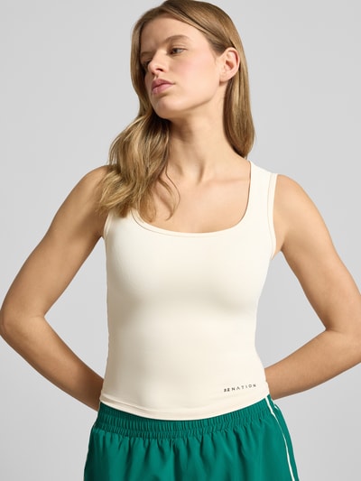 Frauenmodel trägt Slim Fit Top mit Logo-Detail Modell 'Refine' von P.E Nation im Elastischer-Material-Mix, cremefarben, Rückenlänge 45 cm, Nahaufnahme Oberkörper.