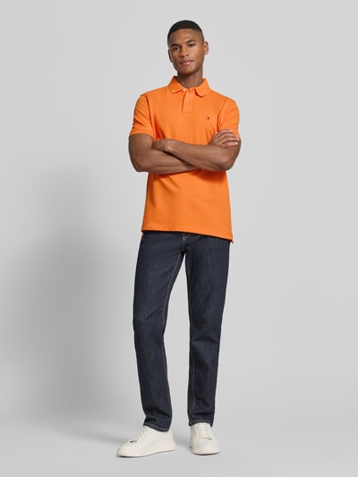 Männermodel trägt Regular Fit Poloshirt aus Baumwoll-Mix von Tommy Hilfiger, Optik: Unifarben, Logo-Stitching, Ganzkörperansicht von vorne.
