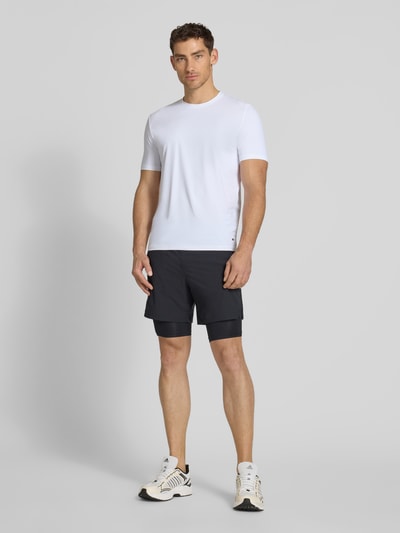 Männermodel trägt T-Shirt mit Rundhalsausschnitt Modell 'TESSUTO' von MARKUP, weiß, Modern Fit, glatte Oberfläche, Ganzkörperansicht von vorne.
