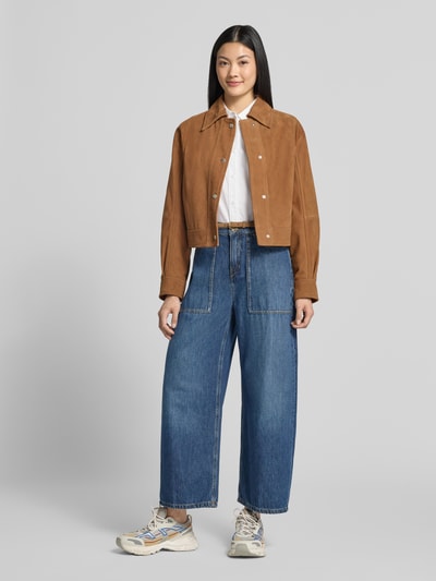 Frauenmodel trägt Wide Fit Jeans mit Baumwoll-Anteil Modell 'Derive' von DRYKORN in Blau mit aufgesetzten Taschen, Material-Mix, Ganzkörperansicht von vorne.