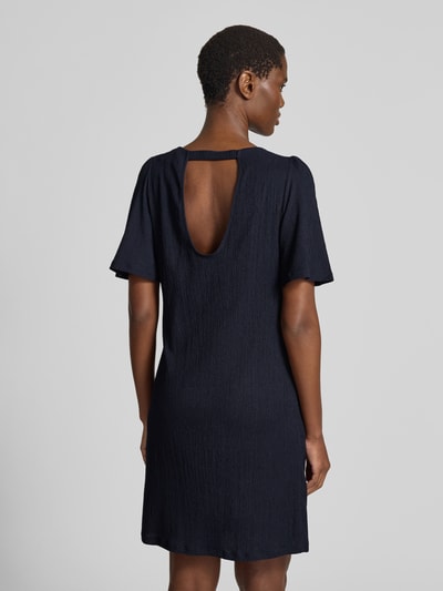 Frauenmodel trägt Knielanges Kleid mit Rundhalsausschnitt von Zero, dunkler Material-Mix mit Stretch-Anteil, gerader Schnitt, Knielänge, Rückenausschnitt, Struktur-Textur, Rückenlänge bei Größe 36: 91 cm, Brustweite: 48 cm, Ärmellänge: 31 cm, Ganzkörperansicht Rückansicht.