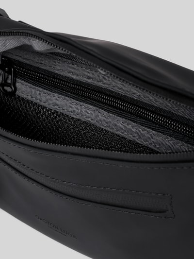 Produktfoto, Bauchtasche mit Logo-Detail Modell 'SPLÄSH BUMBAG' von GASTON LUGA in Schwarz, Reißverschluss, strukturierte Oberfläche, Nahaufnahme Hauptfach, Hauptfachdetails und Reißverschluss sichtbar, Kontext: Herren Bauchtasche mit verstellbarem Trageriemen, Größe 32x15x4 cm, Schulterriemen 88 cm.