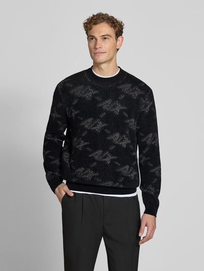 Männermodel trägt Regular Fit Pullover mit Viskose-Anteil von Armani Exchange, Schwarz mit Camouflage-Muster, Material-Mix, Ganzkörperansicht von vorne.
