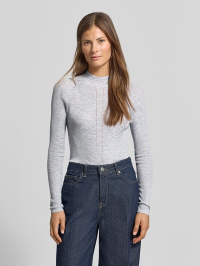 Frauenmodel trägt Strickpullover mit Woll-Anteil von MYON, hellgraue Ripp-Optik, Lochmuster vorne, Stehkragen, Ganzkörperansicht von vorne. Damen Strickpullover, eng anliegende Passform, Rückenlänge 58 cm, Ärmellänge 64 cm.
