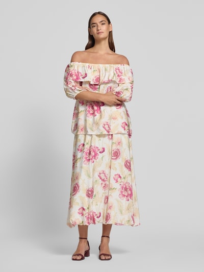 Frauenmodel trägt Midirock aus Viskose-Mix Modell 'Maise' von FREE/QUENT, floraler Allover-Look, hell mit rosa und grünen Akzenten, Ganzkörperansicht von vorne.