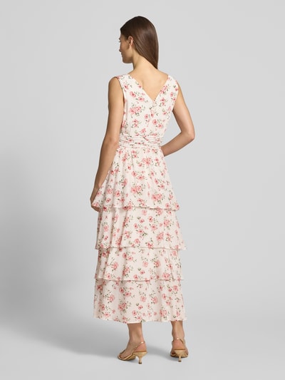 Frauenmodel trägt Cocktailkleid aus Viskose im Stufen-Look von GUIDO MARIA KRETSCHMER WOMAN mit floralem Muster in zarten Pastelltönen, Ganzkörperansicht Rückansicht.