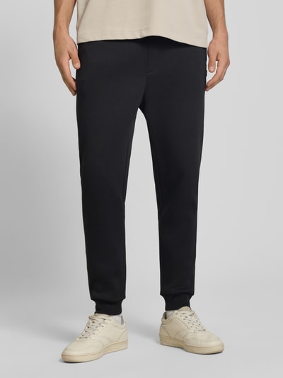 Mannenmodel draagt zwarte Regular Fit sweatpants met steekzakken Model 'GORDON' van JACK & JONES, Materiaalmix met katoen, elastische band met tunnelkoord, gulp, steekzakken, achterzak, binnenbeenlengte bij maat M 70 cm, Ganzkörperansicht van voren.