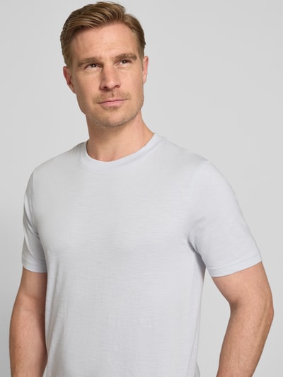 Männermodel trägt Regular Fit T-Shirt mit Rundhalsausschnitt von MCNEAL, reine Baumwolle, weiß, glatte Textur, Nahaufnahme Oberkörper.