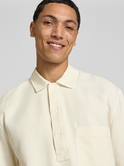 Männermodel trägt Regular Fit Poloshirt mit Brusttasche von Officine Générale in Creme, reine Baumwolle, Nahaufnahme Oberkörper