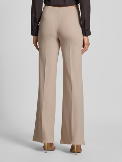 Vrouwenmodel draagt Flared Fit Stoffhose mit Bügelfalten van Rinascimento in beige met stretch, persplooien, elastische band, materiaalmix, bandwijdte maat S 38 cm, binnenbeenlengte 85 cm, Ganzkörperansicht achteraan.