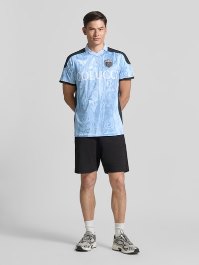 Männermodel trägt Slim Fit T-Shirt mit Label-Print von COLUCCI in Hellblau mit Polokragen, schwarze Akzente, Ganzkörperansicht von vorne. Rückenlänge bei Größe M: 72 cm.