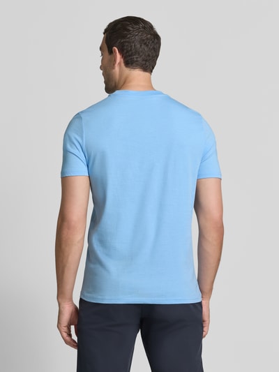 Mężczyznamodel nosi t-shirt z nadrukiem z logo i okrągłym dekoltem od MCNEAL, wykonany z bawełny, krój regular fit, długość tyłu 68 cm w rozmiarze M, widok całej sylwetki z tyłu.