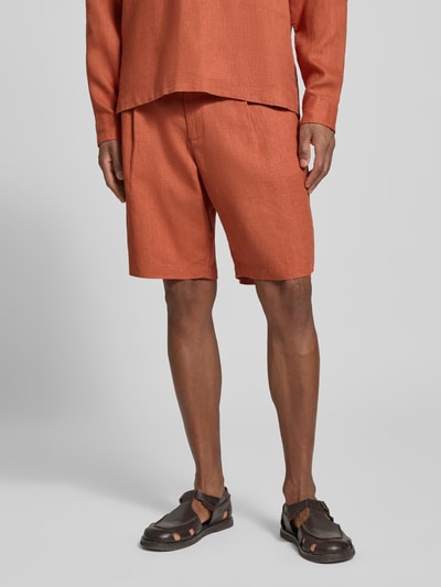 Mannenmodel draagt Bermudas uit zuiver linnen van JAKE*S STUDIO MEN in oranje, losse pasvorm met knoop- en ritssluiting, bandplooien, riemlussen, steekzakken en achterzak, bandwijdte maat M 45 cm, binnenbeenlengte 24 cm, detailopname benen en middel, voorkant.
