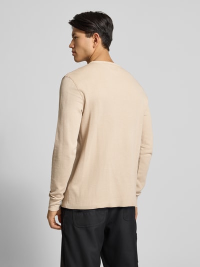 Męskimodel nosi Regular Fit Langarmshirt aus reiner Baumwolle od Tommy Jeans, efekt: jednolity kolor, faktura, aplikacja z logo, gładki materiał, długi rękaw, okrągły dekolt, elastisch zakończenia rękawów, Ganzkörperansicht Rückansicht.